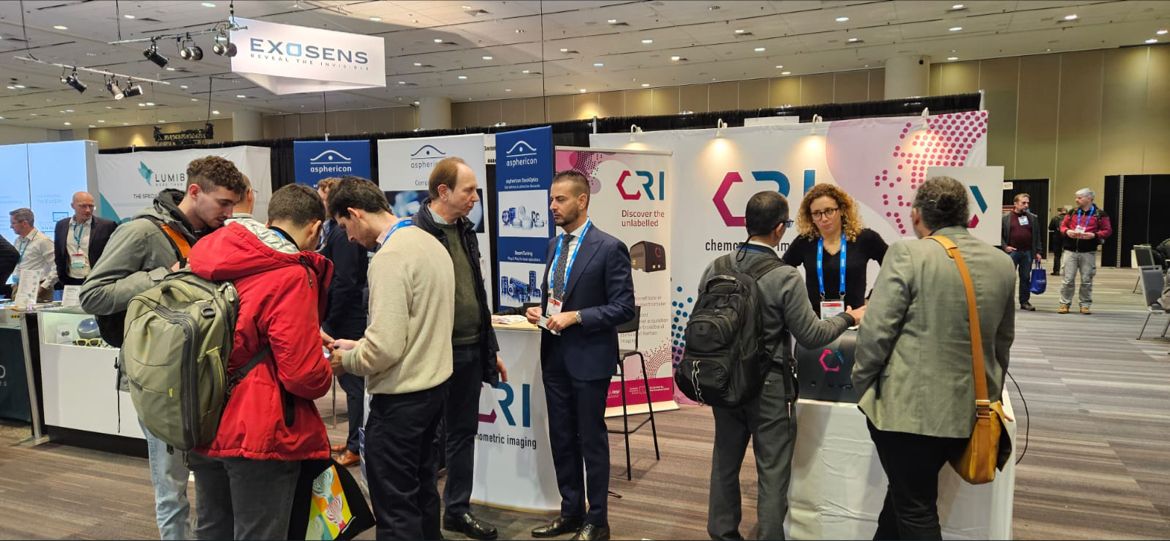 People talking at a conference near a stand.